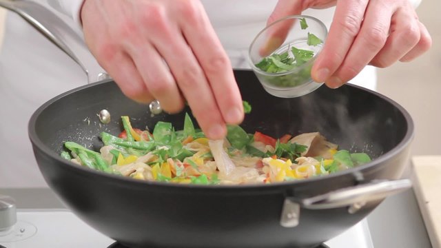 Fresh herbs being added to chicken curry