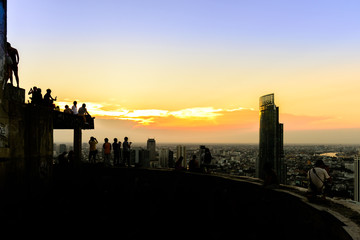 Silhouetted of travellers enjoying with cityscape view at sunset