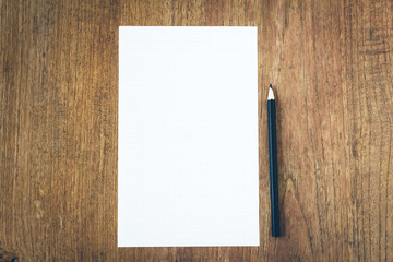 white paper with black pencil on wooden table