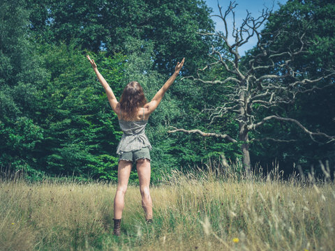 Woman raising her arms in forest