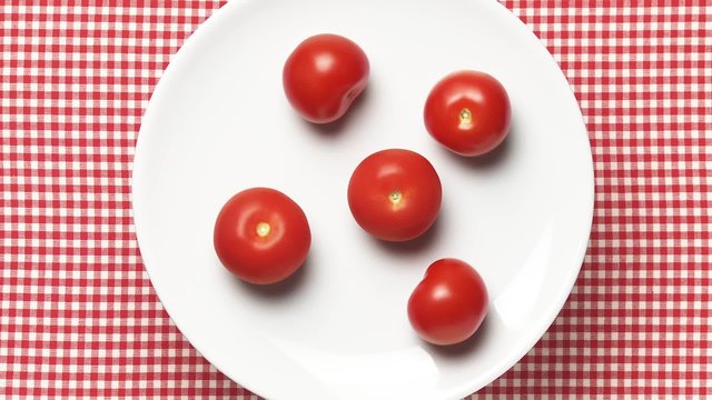 Five tomatoes on a rotating plate