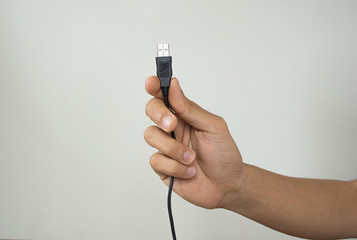 Closeup of hand holding USB cable