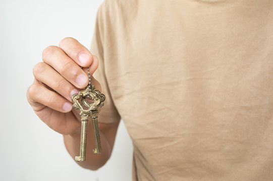 gold key chain with key in hand