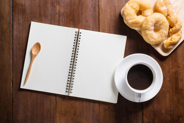 Recipe notebook, donuts, Coffee cup on wooden background, top vi