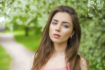 Naklejka premium Portrait of beautiful young brunette woman in spring blossom