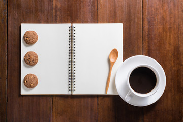 Recipe notebook, Coffee cup, cookie on wooden background, top vi