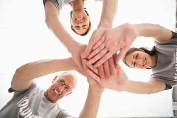 Smiling volunteers putting hands together