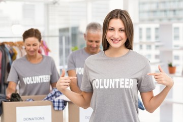 Smiling female volunteer pointing on shirt