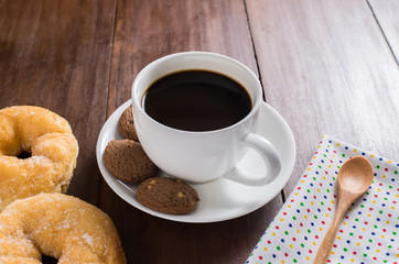Coffee cup, donuts, cookie on wooden background