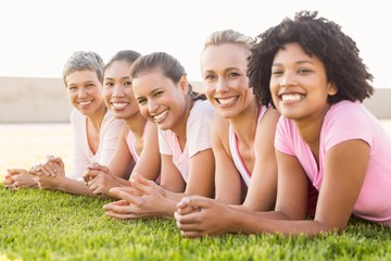 Smiling women lying in a row and wearing pink for breast cancer