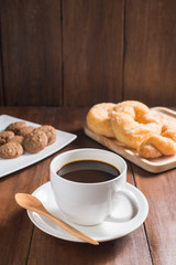 Coffee cup, donuts, cookie on wooden background