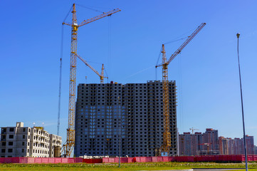 High-rise building under construction, the cranes and blue sky