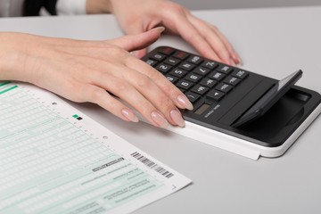 Hand mit Taschenrechner und Steuererkl&auml;rung