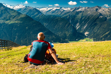 daddy with child looking at mountain peaks and paragliders in austrian alps
