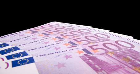 Various 500 euro notes isolated on black background