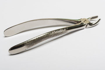 Chromed dental pliers on a blank white background.