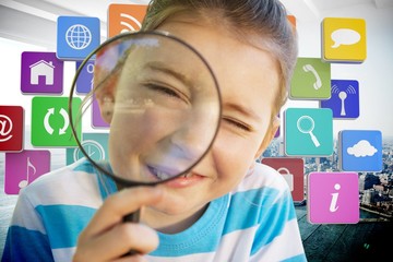 Composite image of cute little girl looking through magnifying 