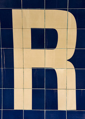 The letter R in Yellow on blue wall tiles - 89519273