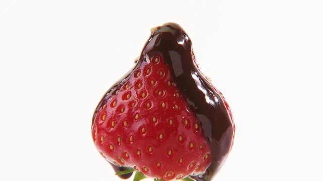 A strawberry with chocolate icing and grated coconut