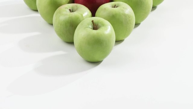 Green apples and one red apple arranged in a triangle