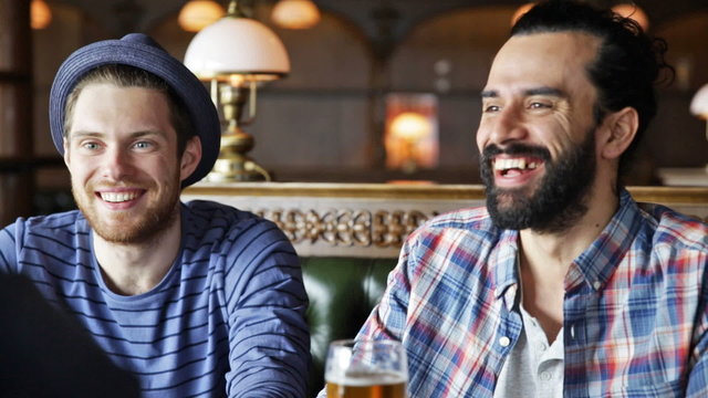 happy male friends drinking beer at bar or pub