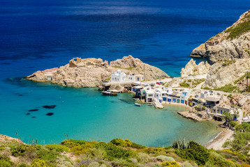 Scenic Firopotamos village (traditional Greek village by the sea, the Cycladic-style) with sirmate - traditional fishermen's houses, Milos island, Cyclades, Greece.