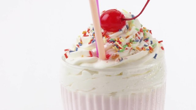 Milkshake with cream, sprinkles and cocktail cherry