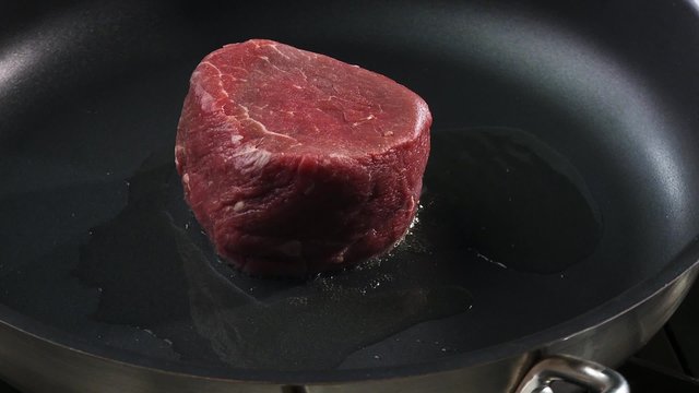 Frying beef fillet in a frying pan