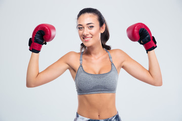 Fitness woman standing with boxing gloves in victory pose