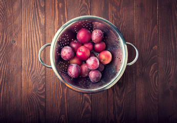 Fresh ripe plums on wooden board