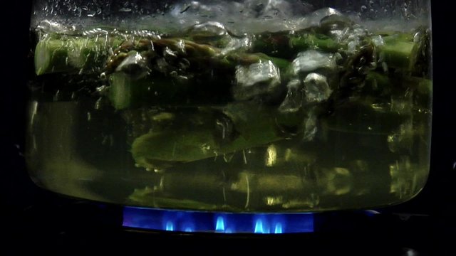 Asparagus tips being cooked in hot water