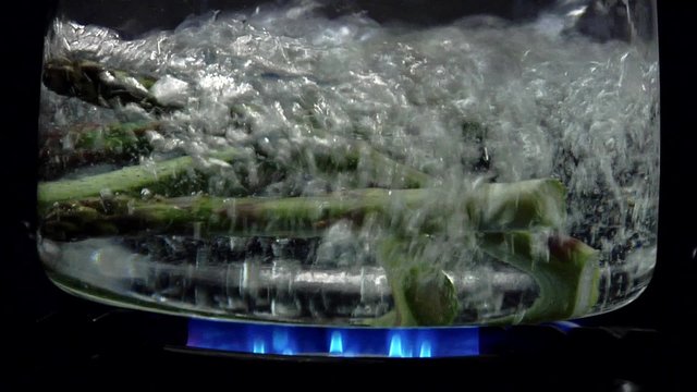 Asparagus tips falling into boiling water