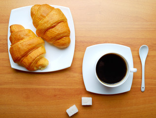 coffee with pieces of sugar and croissants
