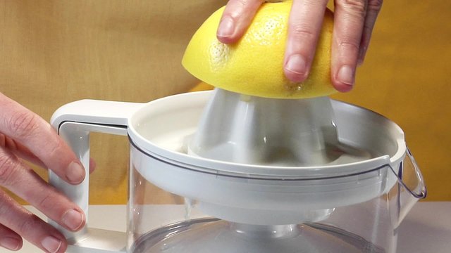 Squeezer a grapefruit with an electric citrus squeezer
