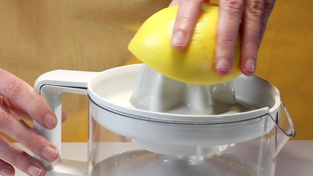 Squeezer a grapefruit with an electric citrus squeezer