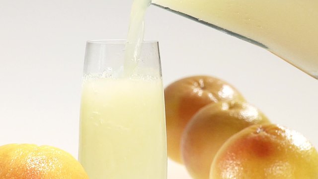 Pouring grapefruit juice into a glass of crushed ice