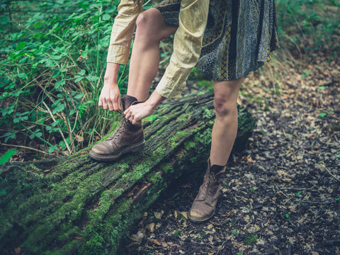 Woman tying her shoes in the forest
