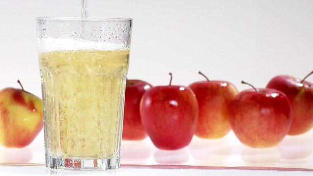 Pouring apple juice into a chilled glass