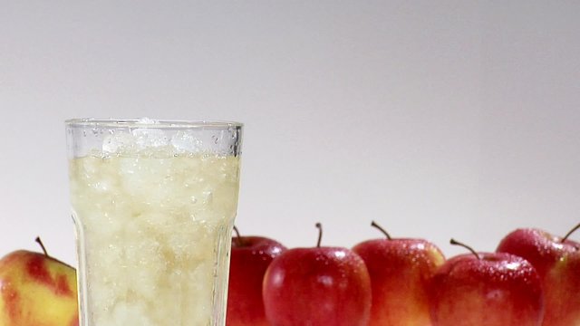 Pouring apple juice into a glass of crushed ice