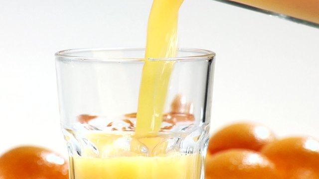 Pouring orange juice into a glass (close-up)