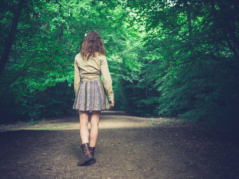 Young woman walking on road in forest