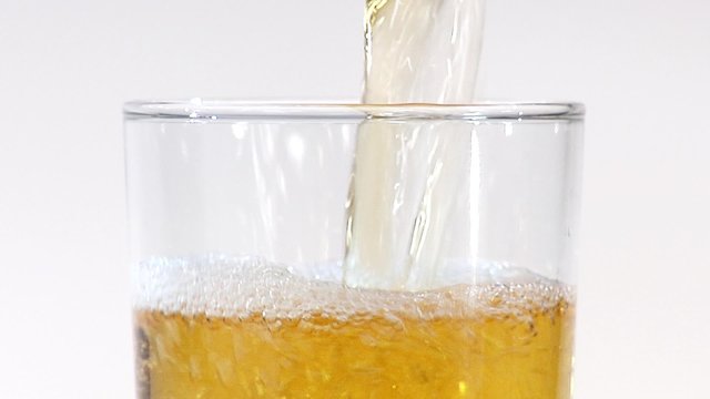Pouring apple juice into a glass (close-up)