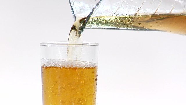Pouring apple juice from a jug into a glass