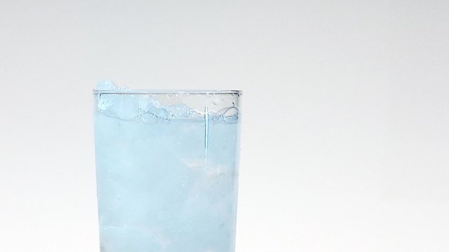 Pouring water into a glass of crushed ice