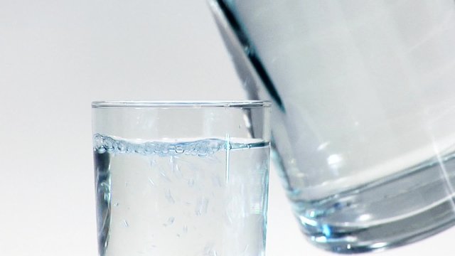 Pouring water from a jug into a glass