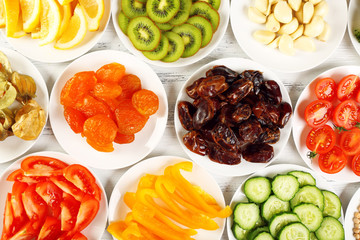 Different products on saucers on wooden table, top view