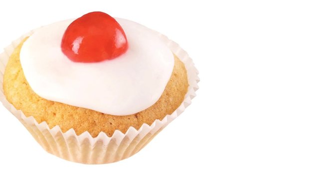 A cupcake with a glacé cherry