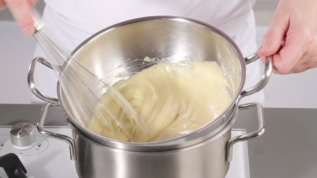Whisking zabaglione over simmering water until pale and fluffy