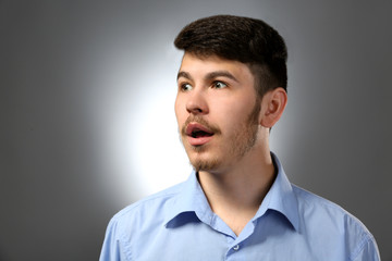 Portrait of surprised man on gray background