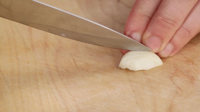 Halving a garlic clove and chopping roughly